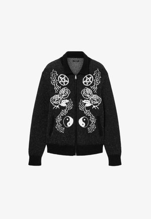 Cardigan negro con cremallera y patrones gráficos en blanco de rosas, pentáculos y símbolos de yin-yang. Hecho de un tejido texturizado con un collar.