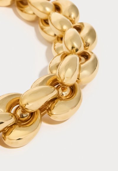 Χρυσό κολιέ με στρογγυλεμένους, αλληλοσυνδεόμενους κρίκους με γυαλιστερή, αντανακλαστική επιφάνεια, που παρουσιάζει ομοιόμορφη υφή και αρμονικό σχεδιασμό.