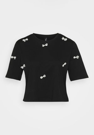 Musta puuvillane t-särk, millel on lühikesed varrukad ja dekoratiivsed valged lipsu appliigid, mis on hajutatud üle eesmine ja varrukatel.