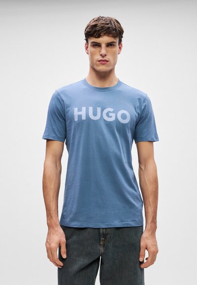 Синя памучна тениска с голямо бяло лого "HUGO" отпред, къси ръкави и стил тип crew neck.