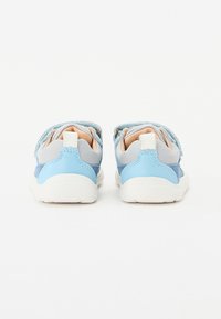 Zapatos infantiles en azul y gris con верхом de tela texturizada, suela de goma blanca, cuello acolchado y cierre de tira de Velcro.