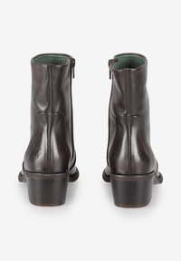 Braune Lederknöchelstiefel mit glatter Oberfläche, seitlichen Reißverschlüssen und einem niedrigen Blockabsatz. Innen mit kontrastierendem grünen Futter.