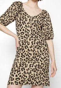 Leopardi-kuosiset mekko lyhyillä puff-hihnoilla, valmistettu teksturoidusta kankaasta. Ominaisuuksiin kuuluu pyöreä pääntie ja vartalonmyötäinen malli beige- ja mustissa sävyissä.