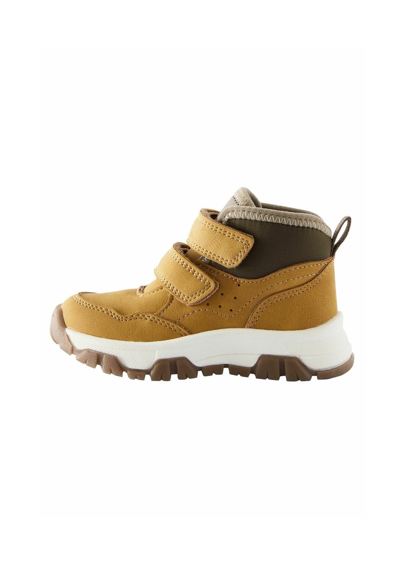 Bruna och gula högstövlar i sneakers som har en texturerad överdel, två justerbara kardborreband och en vit gummisula med ett grovt mönster.