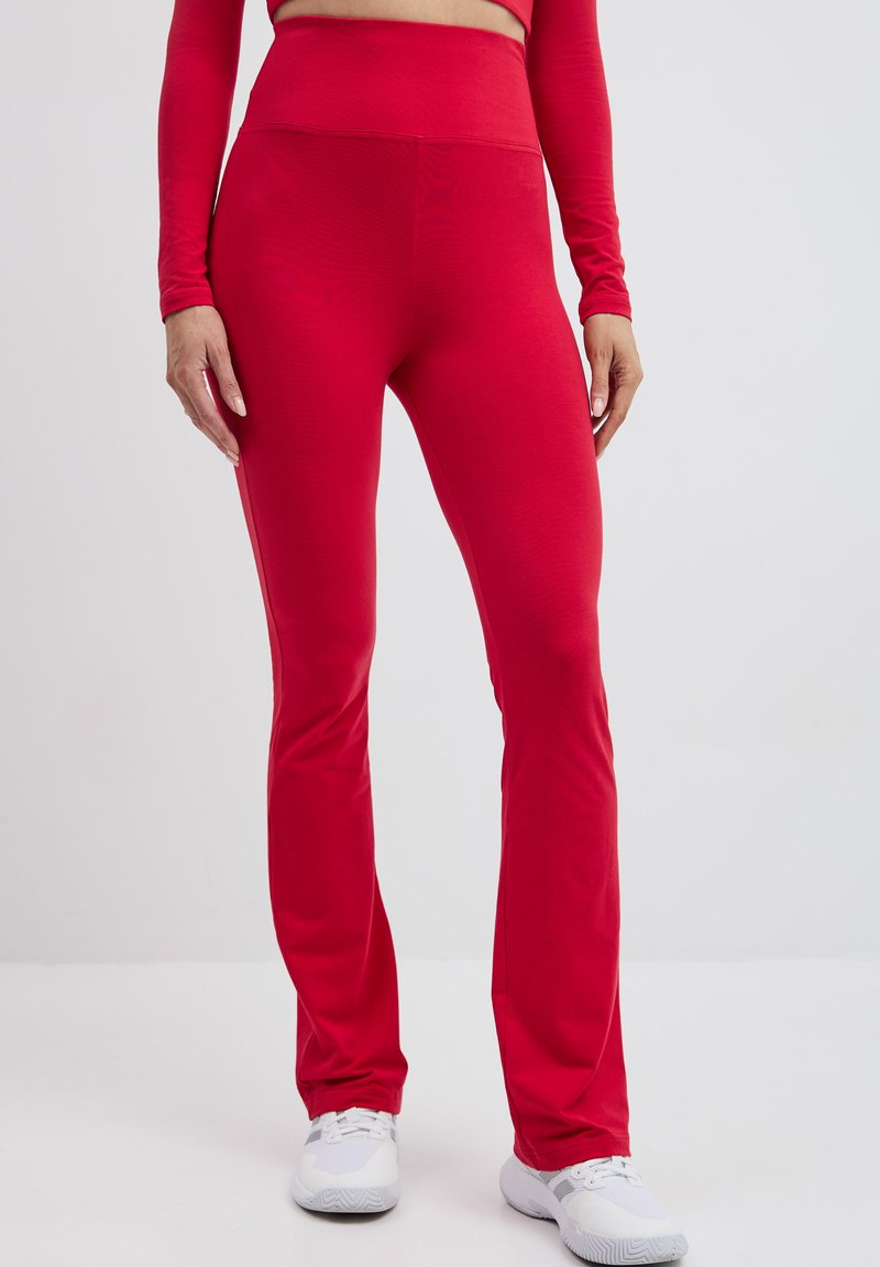Czerwone legginsy fitness z wysokim stanem, wykonane z gładkiego, elastycznego materiału, z szerokimi nogawkami i minimalnymi dodatkami.