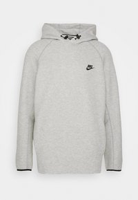 Sudadera Nike gris clara con logotipo negro en el pecho, capucha ajustable con cordón y ribetes negros en los puños de las mangas.
