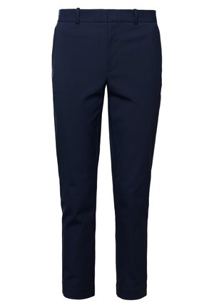 Tummansiniset miesten slim fit -housut, joissa vyölenkit ja edessä vetoketjusuljin, valkoista taustaa vasten.