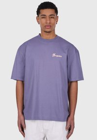 Lilla bomulds T-shirt med afslappet pasform, rund hals og korte ærmer. Har et lille pink "Dropsize" logo på venstre bryst.