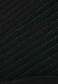 Czarny materiał z pionowymi teksturowanymi paskami, z wzorem naprzemiennych cienkich zielonych linii. Miękki, rozciągliwy materiał.