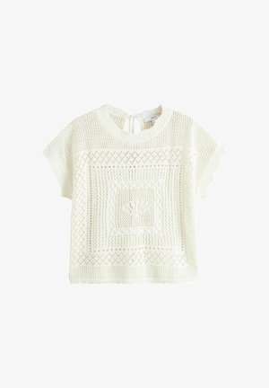 Valkoinen lyhythihainen neulotun kangas, jossa avoin kirjoneulekuvio, resorireunat, pyöreä kaula-aukko ja pieni solmittava nauha takana.