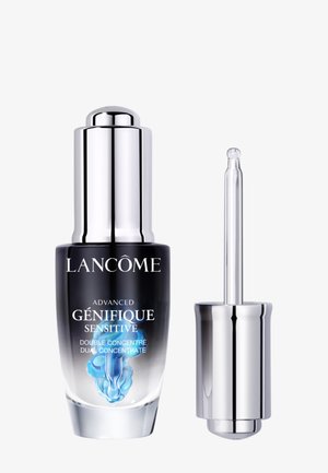 Flasche des Lancôme Advanced Génifique Sensitive Serums mit silbernem Deckel und Pipette, die die blaue Flüssigkeit im Inneren zeigt.