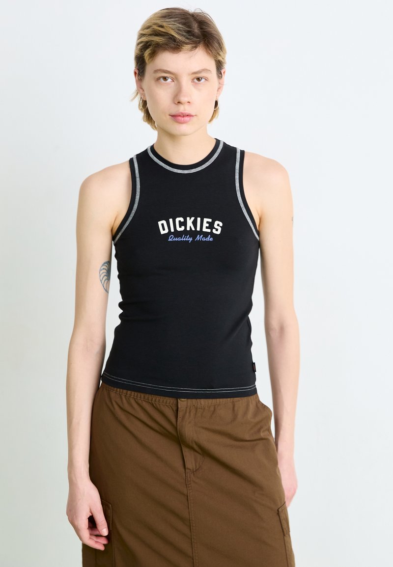 Svart tank top med hvit og blå "DICKIES Quality Made"-logo, med ribbestrikket hals og ermehull, kombinert med brune bukser.