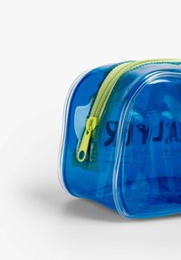 Bolsa de plástico azul translúcida con forma redondeada, que cuenta con un cierre y herrajes en color verde lima, ideal para organizar pequeños objetos.