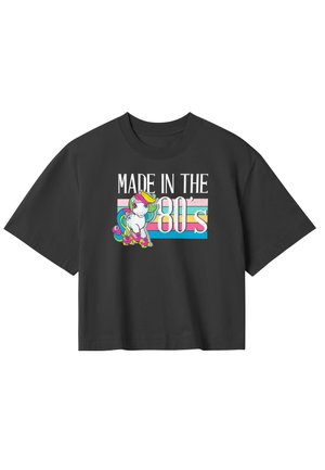 T-shirt nera a maniche corte con la scritta "Made in the 80's" e una grafica colorata di un unicorno in cartone animato con criniera arcobaleno e pattini a rotelle.