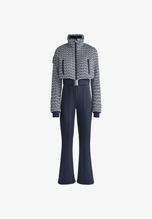 Tengerészeti síruházat, amely egy rövidített, texturált kabátból áll, magas gallérral és elöl cipzárral, flared nadrággal és övvel ellátott derékkal párosítva.