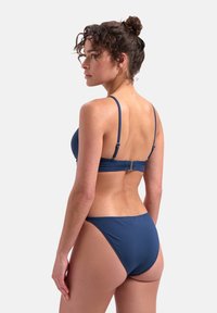 Set di bikini blu navy con spalline regolabili, chiusura a clip sul retro e tessuto elastico liscio con copertura minima.