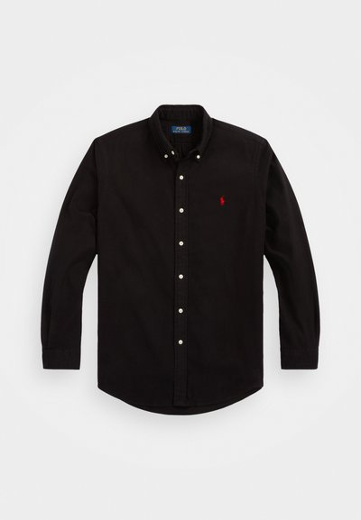 Melnas garām piedurknēm pogājama krekls izgatavots no kokvilnas, ar klasisku apkakli, baltām pogām un mazu sarkanu logo uz krūtīm.