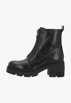 Bottines en cuir noir avec une fermeture éclair sur le côté, semelle épaisse et talon bloc. Elles comportent des coutures discrètes et un logo sur le côté extérieur.