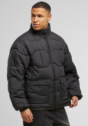 Sort puffjakke med høj krave, der har en quilted design, front lynlåslukning og to knap-lukkede lommer. Struktureret stofoverflade.