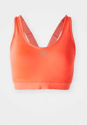 Jasnopomarańczowy biustonosz sportowy z plecami w kształcie wyścigu i regulowanymi ramiączkami, z małym odblaskowym logo New Balance na centrum przodu.
