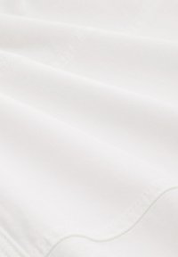 White fabric with a smooth texture and subtle sheen, featuring stitched edges. The material appears lightweight and slightly stretchy.