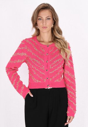 Rosa Strickjacke mit strukturiertem Zickzackmuster, goldenen Akzenten und dekorativen Knöpfen. Kurz geschnitten mit langen Ärmeln.