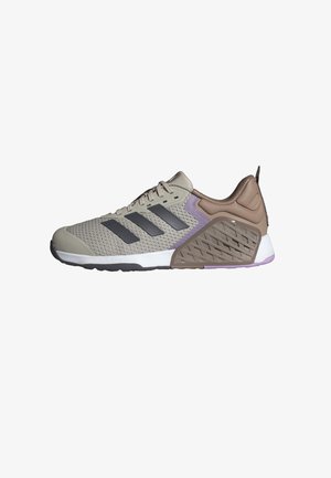 Baskets de sport avec tige en mesh beige, trois bandes noires sur le côté, maintien du talon marron rembourré et semelle blanche avec accents violets.