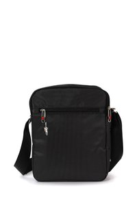 Schwarze Nylontasche mit strukturierten Oberflächen, ausgestattet mit einem oberen Reißverschluss, verstellbarem Tragegurt und einem kleinen dekorativen Metallanhänger.