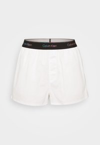 Vita bomullsboxershorts med svart elastisk midjeband som har Calvins Klein-logotypen i multikolorerad text, knapplås.