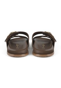 Brown slide sandals with dual straps, textured material, and a gold-tone buckle accent. Comfortable footbed and flat rubber sole.