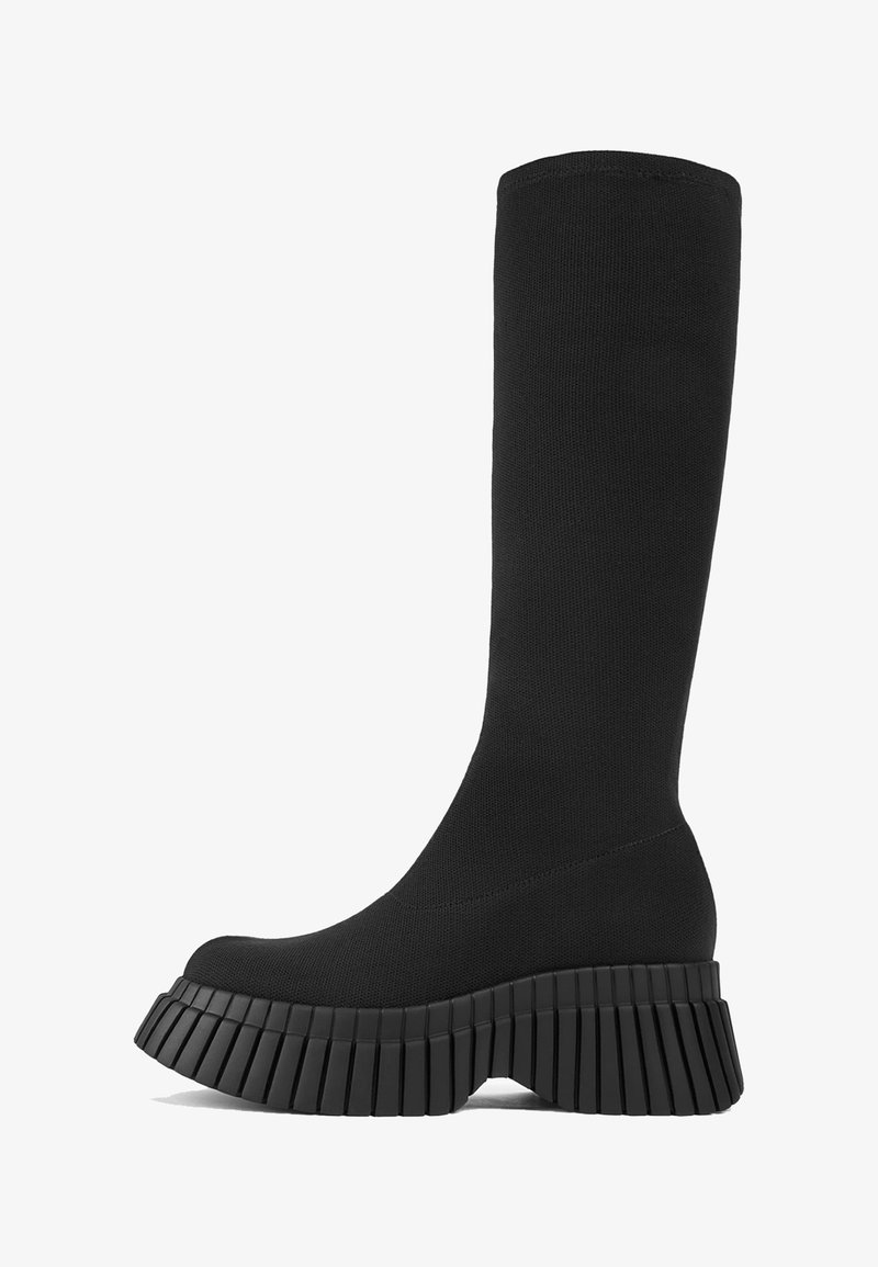 Čierne kožené vysoké čižmy s rebrovanou platformou a štruktúrovaným zvrškom. Elegantný, tesne priliehajúci dizajn s okrúhlou špičkou a bez viditeľných kovových prvkov.
