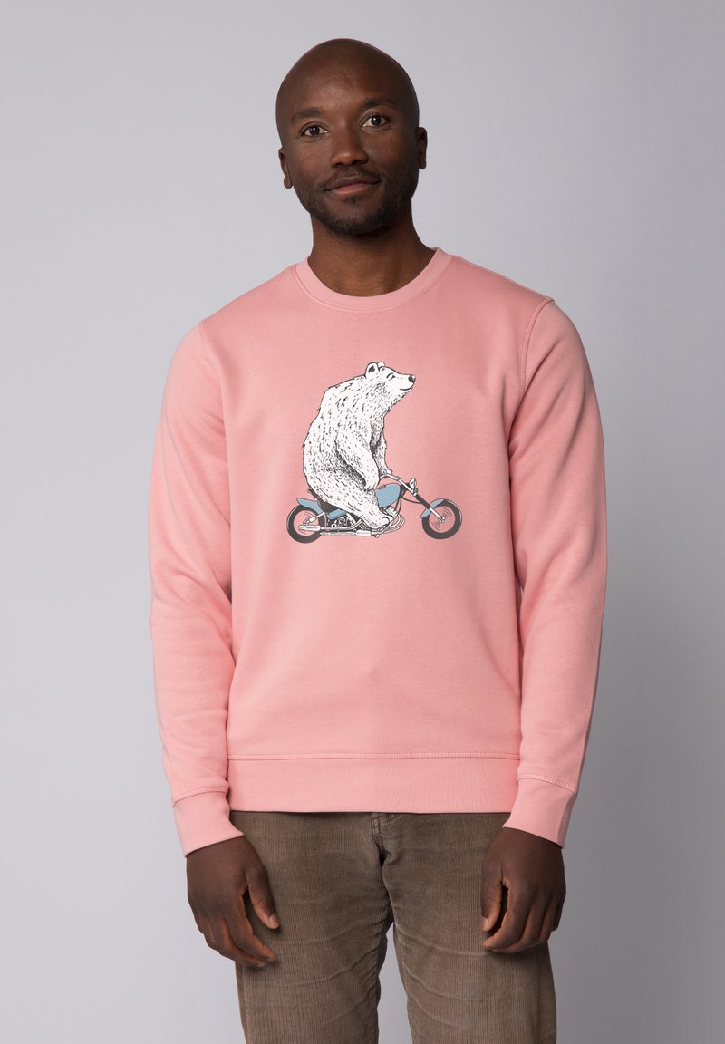 Sweatshirt rose avec un graphique d'ours blanc montant un vélo bleu. Texture douce, col rond et poignets côtelés. Conçu avec une coupe décontractée.