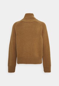 Brun stickad tröja med hög krage, ribbade ärmslut och nederkant. Designen har en avslappnad passform och texturerad tyg.