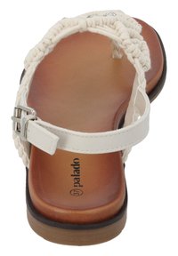 Białe plecione sandały z płaską brązową podeszwą, z regulowaną metalową klamrą i gładką jasnobezową wkładką. Wewnątrz oznaczone "palado".