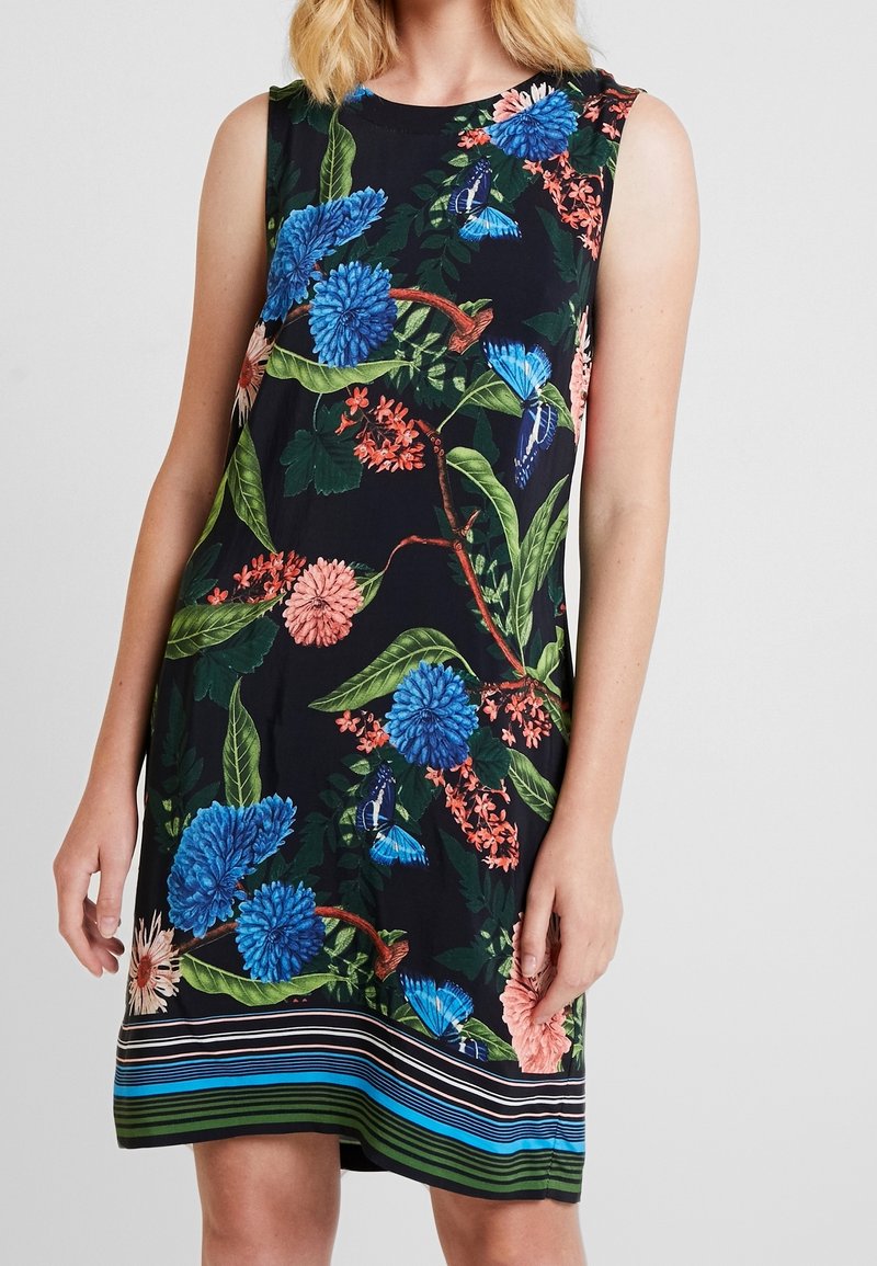 Robe sans manches à fleurs présentant des fleurs bleues et roses sur un fond noir, avec des feuilles vertes et un ourlet rayé en bleu et vert.
