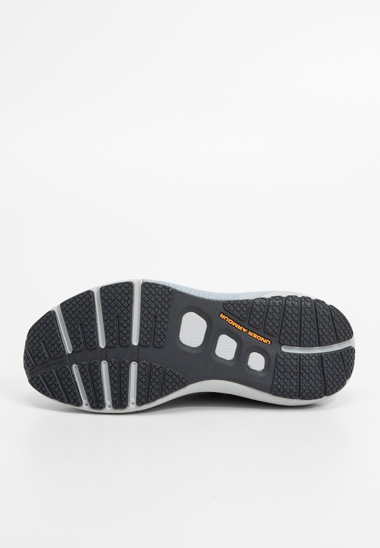 Czarna gumowa podeszwa z szarymi akcentami, z teksturowanymi wzorami dla lepszego uchwytu i licznymi wycięciami dla elastyczności. Wyeksponowane logo Under Armour.