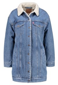 Denimjakke i lyseblå farve med knaplukning, to brystlommer og en hvid falsk pelskrave for ekstra tekstur.