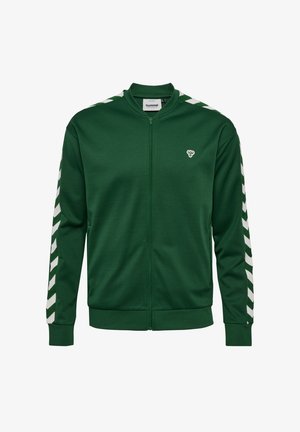 Zaļa zip-up jaka, izgatavota no mīksta auduma, ar baltām chevron svītrām uz piedurknēm un mazu logotipu uz krūšu daļas. Standarta piegriezums.