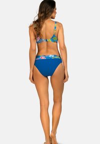 Dwuczęściowy strój kąpielowy z kolorowym wzorem kwiatowym na górze z niebieskimi akcentami oraz jednolitymi, niebieskimi dołami; wykonany z gładkiego, elastycznego materiału.
