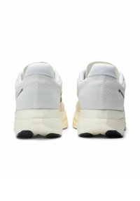 Witte sneakers met een bovenwerk van getextureerd mesh, een gevoerde kraag en een stevige offwhite tussenzool met een zwarte rubberen buitenzool.