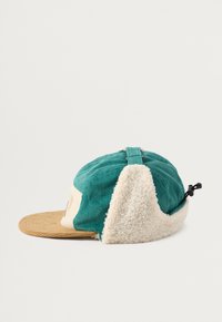 Koondundus ja fleece'i müts, millel on roheline ülaosa, kreemja värvusega kõrvaosa ja beež tekstuuriga ääre. Tagaküljel reguleeritav rihm.