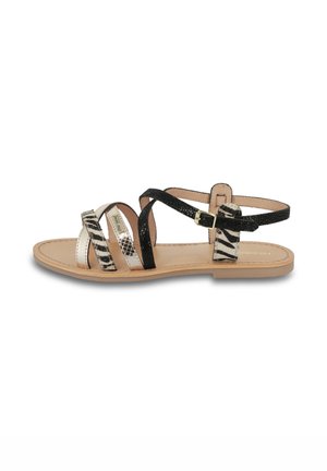 Sandali strappy bianchi e neri con dettagli in stampa animale, finiture metalliche e suola piatta. Caratterizzati da fibbia regolabile alla caviglia.