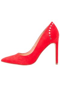 Pompe à talon aiguille rouge en daim avec une pointe effilée, ornée de clous en argent sur le côté, et un talon stiletto élégant. Texture lisse dans l'ensemble.