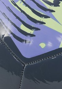 Producto hexagonal con una superficie gris oscuro y brillante. Presenta un patrón vibrante en púrpura y verde. Costura notable a lo largo de los bordes.