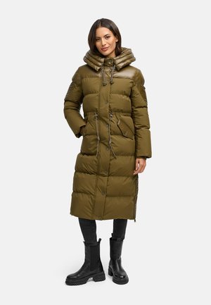 Olijfgroene pufferjas met een capuchon, voorzien van een rits aan de voorkant, knopen, trekkoorden en zakken aan de zijkant. Draagt over zwarte broek en laarzen.