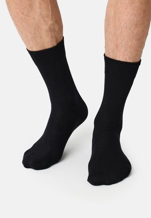 Schwarze Baumwollsocken mit glatter Textur und klassischer Knöchelhöhe, ausgestattet mit einem gerippten oberen Band für einen sicheren Sitz.