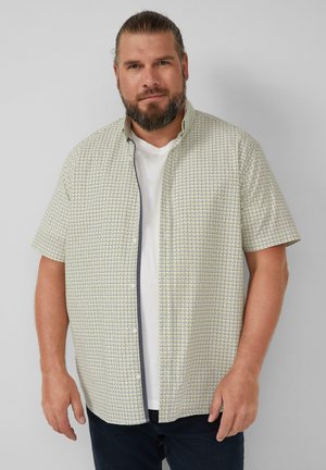 Korte mouwen shirt in een lichte roomkleur met een geometrisch patroon in donkerblauw. Heeft een knoopsluiting aan de voorkant en een zachte katoenen textuur.