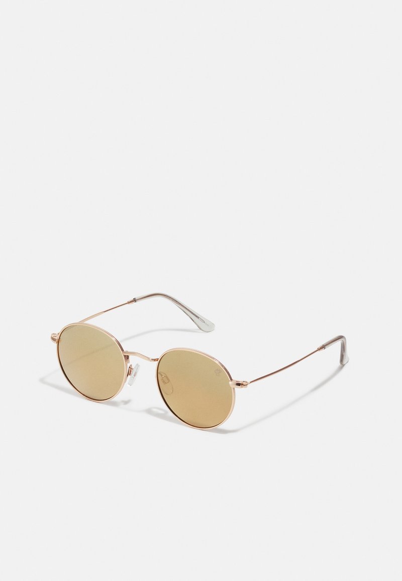Round sunglasses with a thin rose gold metal frame, light brown lenses, and slender silver temples. Minimalist design with no visible logos.