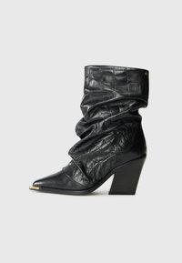 Black leather mid-calf slouchy boot with crocodile texture, pointed toe, gold tip, and chunky high heel on a white background.