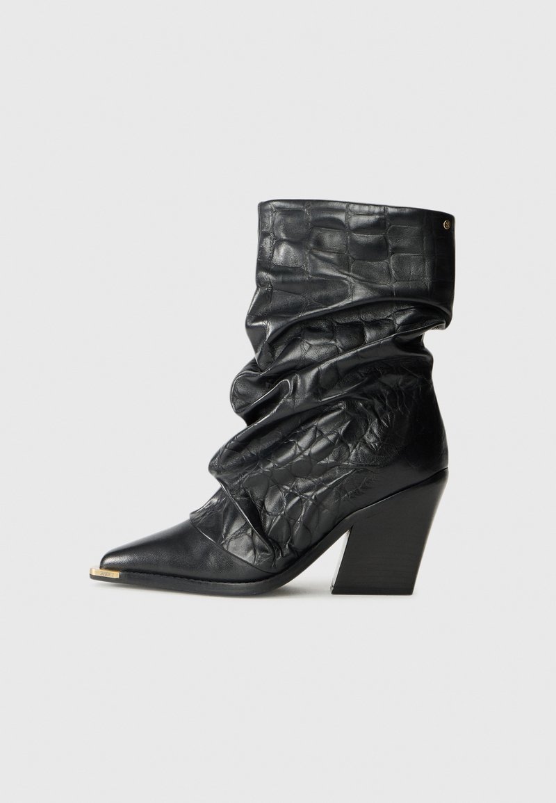 Black leather mid-calf slouchy boot with crocodile texture, pointed toe, gold tip, and chunky high heel on a white background.